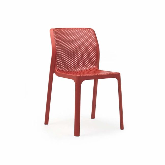 Silla BIT de color coral. Sin brazos, hecha de una sola pieza y con el asiento y el respaldo con un patrón de ranuras cuadradas y redondeadas que forman una red