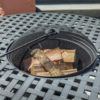 ROSARIO Barbecue Set - Hartman. The barbecue is shown filled with unlit wood and with the poker hooked onto the mesh screen.