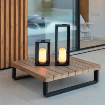 SIROCO portable metal lantern, on a low wooden table with anthracite legs