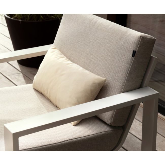 Conjunto Relax Marsala, foto ambiente del sillón se ve su estructura blanca de líneas rectas y limpias salvo en la parte que une el asiento al respaldo