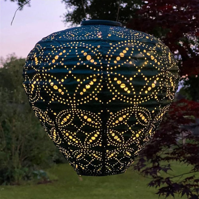 Balloon Solar Lantern MANDELA Blue - Lumiz photo of the late-night atmosphere, the lantern is on although there is still light and you can see a garden and part of a tree