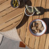 FINN coffee table set by 4 Seasons Outdoor. Two very eye-catching tables, made entirely of teak. The Ø80cm table has a height of 30cm and the Ø60cm table has a height of 35cm, both with three round legs. Overhead view detail of the tabletops with a 4SO rug visible below.