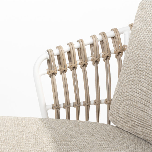 DALIAS Chair - 4 Seasons Outoor® includes seat and back cushions in beige and tan beige. Chair with a white tubular steel structure, embellished with hand-woven hularo wicker around the structure in a toasted beige tone imitating traditional wicker. Detail of the armrest and cushions on white background.