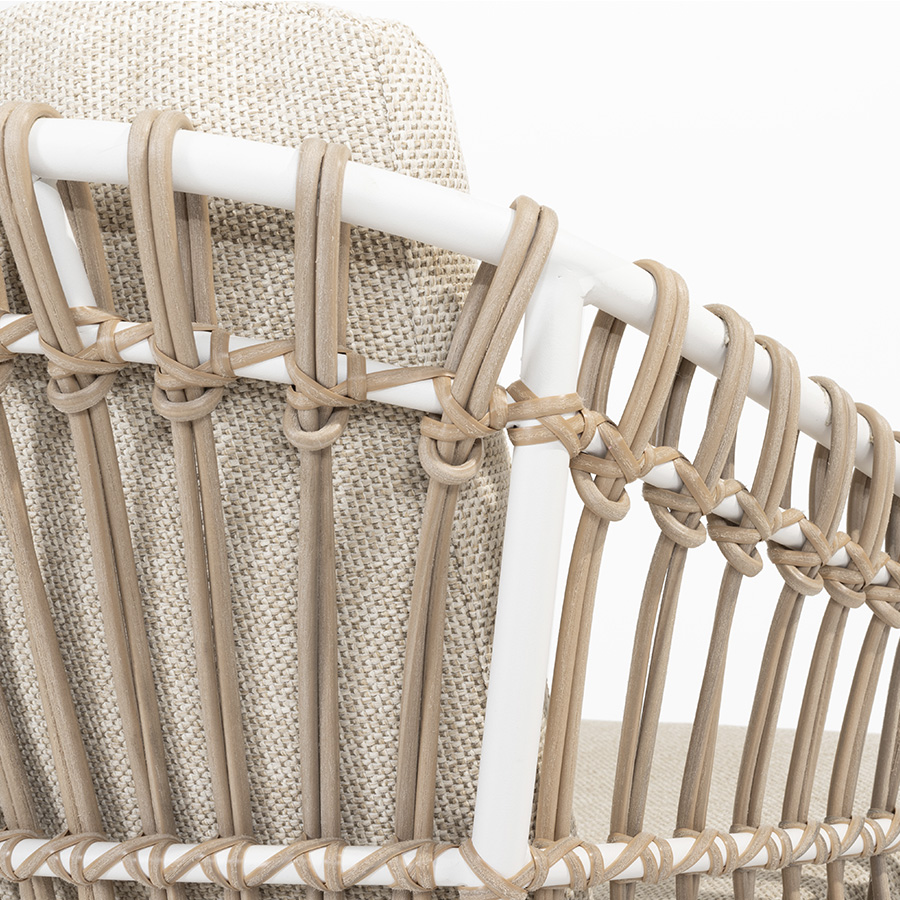 DALIAS Chair - 4 Seasons Outoor® includes seat and back cushions in beige and tan beige. Chair with a white tubular steel structure, embellished with hand-woven hularo wicker around the structure in a toasted beige tone imitating traditional wicker. Detail of the backrest on a white background.