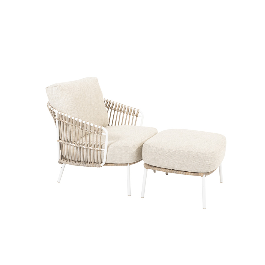 DALIAS armchair with footrest - 4 Seasons Outoor® with thick cushions that maximize the comfort of the seat and backrest, marbled in beige and tan beige. Armchair with footrest with tubular stainless steel structure in white, embellished with hand-woven hularo wicker around the structure in a toasted beige tone imitating traditional wicker. Left side view on white background.