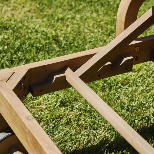 Tumbona madera Ravona de GardenLine con reposabrazos, cojín con cremalleras y ruedas, ajustable en 4 posiciones. Detalle del ajuste de madera para subir y bajar el respaldo de la tumbona de madera.