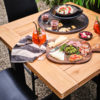Mesa bar Yasmani 100 de Hartman Con patas de aluminio en antracita y tablero de teca. Una mesa de diseño moderno y robusto, que le aporta estabilidad a esta mesa de bar para jardín.