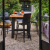 Mesa bar Yasmani 100 de Hartman Con patas de aluminio en antracita y tablero de teca. Una mesa de diseño moderno y robusto, que le aporta estabilidad a esta mesa de bar para jardín.