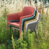 Sillón Net Relax de Nardi Foto ambiente seis sillones Net relax uno de cada color disponible apilados en un campo con hierba alta. Con el característico patrón calado de rombos de la serie NET. Cómpralo online de forma segura en De Tropen la mayor tienda de muebles de jardín de Málaga.