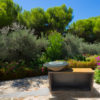 Barbacoa de leña Acero Corten 100 y base de De Tropen Una obra maestra funcional y práctica para tu jardín de líneas simples y limpias. Se trata de un cono de acero corten sobre el que descansa un disco de 2cm de acero negro Ø100 con un hueco de Ø50cm en el centro. Viene con rejilla para la leña, parrilla y un removedor de ascuas. Va colocada sobre una base de Acero corten de 150x43x78 que sirve de leñero y mesa de trabajo para el cocinado.