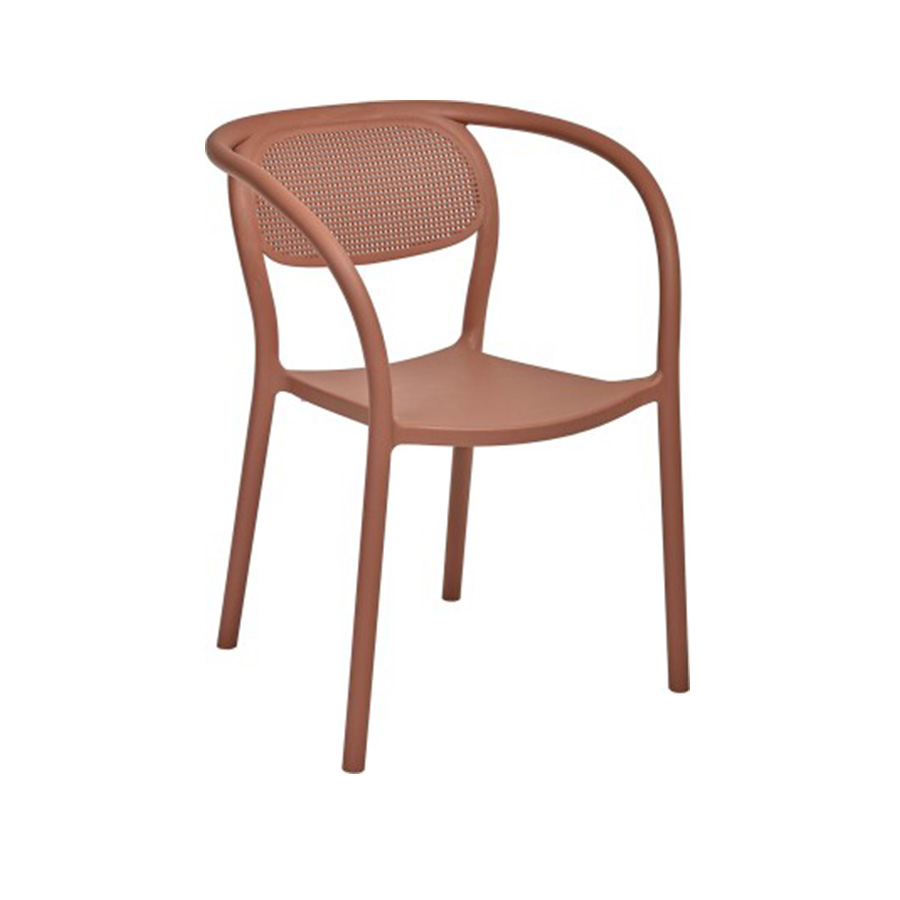 The Noon armchair in Terracotta, a terracotta orange, is from the Valencian brand Ezpeleta. Its matte finish adds to its sophistication. Made of fiberglass-reinforced polypropylene, it's a very comfortable chair, especially thanks to the curved backrest that cradles and supports the back. The same line runs through the front legs, armrests, and backrest, seamlessly blending into the rest of the structure, as it's a single, monoblock piece. The backrest mimics the weave of classic rattan, forming circles that allow air to circulate. It features non-slip feet and UV protection. It's 100% recyclable and suitable for both indoor and outdoor use. Ideal for residential and public spaces. Find it at De Tropen, your outdoor furniture expert. Oblique front view.