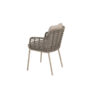 Silla Puglia de 4SO Vista oblicua se ve la silla hecha de acero inox y terminada en un color latte (café con leche o beige tostado, color tendencia del 2025) que se embellece con la cuerda en color topo anudada a la estructura desde los reposabrazos hasta la base del asiento rodeando toda la silla y creado un patrón característico de la colección Puglia. Cómprala en De Tropen, tu experto en muebles de jardín y terraza. Foto frontal del lateral de la silla oblicua sobre fondo blanco.