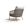 Sillón Puglia de 4SO Vista oblicua se ve el sillón hecho de acero inox y terminado en un color latte (café con leche o beige tostado, color tendencia del 2025) que se embellece con la cuerda en color topo anudada a la estructura desde los reposabrazos hasta la base del asiento rodeando todo el sillón y creado un patrón característico de la colección Puglia. Cómprala en De Tropen, tu experto en muebles de jardín y terraza. Foto frontal del lateral del respaldo del sillón oblicuo sobre fondo blanco.