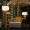 Phoebe 40 and 145 solar table lamps in mustard by NewGarden, lifestyle photo, one on each side of an armchair, on the right the Phoebe 40 on a side table and on the left the 145 standing. Expand your horizons with De Tropen®, come and discover the possibilities of lighting for your terrace or balcony. In the largest garden furniture store on the Costa del Sol, Málaga and Granada.